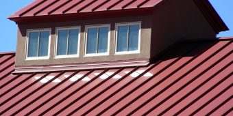Four windows reflecting sunlight on to a roof